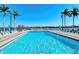 Community pool with lounge chairs and tables, offering waterfront views and palm trees at 5963 Midnight Pass Rd # 355, Sarasota, FL 34242