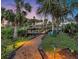 Pathway to a private dock framed by palm trees, offering a peaceful retreat and direct access to the serene waterway at 6222 Stillwater Ct, Bradenton, FL 34201