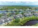 Aerial view of condos, amenities, and gorgeous waterfront view with mature trees at 628 Estuary Dr, Bradenton, FL 34209