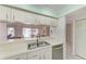 Bright kitchen features stainless steel sink, white cabinetry, and dining room view at 628 Estuary Dr, Bradenton, FL 34209
