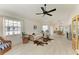 Bright living room features tile floors, ceiling fan, and an open layout leading to the dining area at 628 Estuary Dr, Bradenton, FL 34209