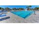 Community pool featuring clear water, lounge chairs, gated fence, and poolside seating at 628 Estuary Dr, Bradenton, FL 34209