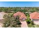 Stunning aerial view of a home with red tile roof, brick driveway, and mature landscaping at 6324 41St E Ct, Sarasota, FL 34243