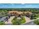 Aerial view of the community clubhouse, tennis courts, lush landscaping with palms and lush green trees at 6324 41St E Ct, Sarasota, FL 34243