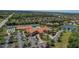 Aerial view of a community clubhouse featuring tennis courts, swimming pool and a large parking area at 6324 41St E Ct, Sarasota, FL 34243