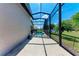 A concrete patio next to a screen enclosed pool surrounded by grassy yard and privacy landscaping at 6324 41St E Ct, Sarasota, FL 34243