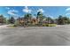 Clubhouse entrance features circular drive and lush landscaping with palm trees and colorful flowers at 6324 41St E Ct, Sarasota, FL 34243