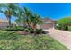 Charming single-story home featuring a well-maintained lawn, tropical landscaping, and brick driveway at 6324 41St E Ct, Sarasota, FL 34243