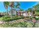 Charming home with well-manicured landscaping, lush green lawn and mature palm trees at 6324 41St E Ct, Sarasota, FL 34243