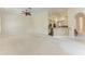 Open living room with view of kitchen, neutral palette, carpeted floor, and fan at 6324 41St E Ct, Sarasota, FL 34243