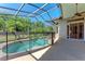 Screened-in pool features lush surroundings and a safety fence with access from the covered patio at 6324 41St E Ct, Sarasota, FL 34243