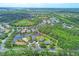 Aerial view of a residential community featuring well-maintained properties, lush landscaping, and scenic lake at 7710 Seven Oaks Dr, Bradenton, FL 34201