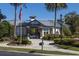 Beautiful community center entrance surrounded by lush landscaping and an American flag waving in the wind at 7710 Seven Oaks Dr, Bradenton, FL 34201