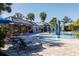 Community pool with a splash pad, lounge chairs and tables and umbrellas for residents' enjoyment at 7710 Seven Oaks Dr, Bradenton, FL 34201