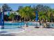 Community pool and splash pad with palm trees and seating areas with umbrellas, perfect for outdoor fun at 7710 Seven Oaks Dr, Bradenton, FL 34201
