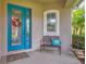 Inviting front porch with a teal door, decorative wreath, bench seating, and a charming welcome mat at 7710 Seven Oaks Dr, Bradenton, FL 34201