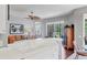 Bright kitchen overlooking a sunroom, featuring white countertops, modern appliances, and hardwood floors at 7710 Seven Oaks Dr, Bradenton, FL 34201