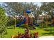 Fun community playground featuring multiple slides and colorful play equipment on a manicured lawn at 7710 Seven Oaks Dr, Bradenton, FL 34201