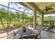 A screened patio with ample space for dining, features views of tropical foliage and well-maintained outdoor space at 7710 Seven Oaks Dr, Bradenton, FL 34201