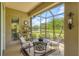 Screened-in patio with seating area overlooking a peaceful pond, offering serene outdoor living at 7710 Seven Oaks Dr, Bradenton, FL 34201