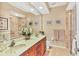 Bathroom with double sinks, large mirror and glass-enclosed shower at 7816 Ashley Cir, University Park, FL 34201