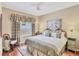 Comfortable bedroom with neutral walls, a ceiling fan, and a window with plaid curtains at 7816 Ashley Cir, University Park, FL 34201