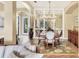 Elegant dining room with tray ceilings, custom light fixture, and large mirror at 7816 Ashley Cir, University Park, FL 34201