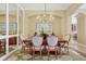 Elegant dining room features a wooden table and upholstered chairs under a modern chandelier at 7816 Ashley Cir, University Park, FL 34201