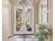 Light and bright foyer with tile floors, art, and double-door entryway at 7816 Ashley Cir, University Park, FL 34201