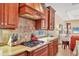 Close up of kitchen with granite counters and cooktop stove, with view into living room at 7816 Ashley Cir, University Park, FL 34201
