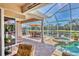 Spacious screened lanai featuring a pool, spa, and outdoor dining area with a scenic lake view at 7816 Ashley Cir, University Park, FL 34201