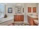 Elegant bathroom with striped walls, soaking tub, and dual sinks at 7816 Ashley Cir, University Park, FL 34201