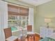 Cozy bedroom seating area by the window with view of pool and lush foliage at 7816 Ashley Cir, University Park, FL 34201