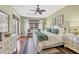 Bright main bedroom with light green walls, white furniture, and tropical accents at 7816 Ashley Cir, University Park, FL 34201