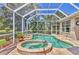 Screened pool and spa area features a built-in spa, lake views, and tile flooring for relaxing entertainment at 7816 Ashley Cir, University Park, FL 34201