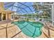 Relaxing screened-in pool with attached spa overlooking a peaceful lake at 7816 Ashley Cir, University Park, FL 34201