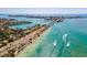 Stunning aerial view of the coastline and bridge with clear turquoise waters and lush greenery at 800 S Blvd Of The Presidents # 3, Sarasota, FL 34236