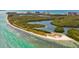 Breathtaking aerial view of sandy island shoreline with crystal clear water, lush green trees and sandy beaches at 800 S Blvd Of The Presidents # 3, Sarasota, FL 34236