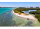Beautiful aerial view of the sandy island shoreline with crystal clear water, lush green trees and sandy beaches at 800 S Blvd Of The Presidents # 3, Sarasota, FL 34236