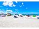 Beautiful beach featuring white sands, clear blue skies, and colorful beachgoers enjoying a sunny day at 800 S Blvd Of The Presidents # 3, Sarasota, FL 34236