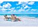Serene beach setting with beachgoers relaxing on lounge chairs enjoying clear skies and turquoise water at 800 S Blvd Of The Presidents # 3, Sarasota, FL 34236