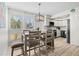 Well-lit dining area with stylish light fixture, seating for four, and bright shuttered windows at 800 S Blvd Of The Presidents # 3, Sarasota, FL 34236