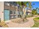 Exterior facade of condos featuring a brick walkway, turquoise doors, and lush tropical landscaping at 800 S Blvd Of The Presidents # 3, Sarasota, FL 34236