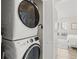 Convenient laundry area with a modern washer and dryer, plus a glimpse into the bright, coastal-style bedroom at 800 S Blvd Of The Presidents # 3, Sarasota, FL 34236