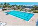 Large outdoor swimming pool with multiple lap lanes and poolside seating areas, surrounded by lush landscaping and palm trees at 800 S Blvd Of The Presidents # 3, Sarasota, FL 34236
