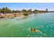 Serene waterfront view with clear turquoise waters, people kayaking, and lush palm trees at 800 S Blvd Of The Presidents # 3, Sarasota, FL 34236