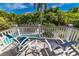 Relax on the balcony with comfortable lounge chairs and a view of the sparkling blue pool at 805 N Bay Blvd, Anna Maria, FL 34216