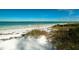 Beautiful beachfront property offers soft, white sand and clear turquoise water perfect for swimming and relaxation at 805 N Bay Blvd, Anna Maria, FL 34216