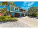 Charming two-story teal home with a screened-in porch, mature landscaping, and a two-car garage at 805 N Bay Blvd, Anna Maria, FL 34216