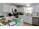 Bright kitchen featuring white cabinetry, stainless steel appliances, and a neutral countertop at 805 N Bay Blvd, Anna Maria, FL 34216